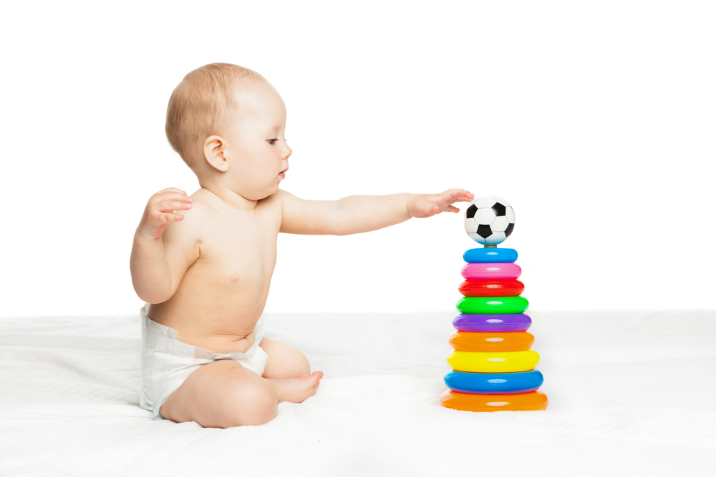 cute baby sitting and playing with colorful toy